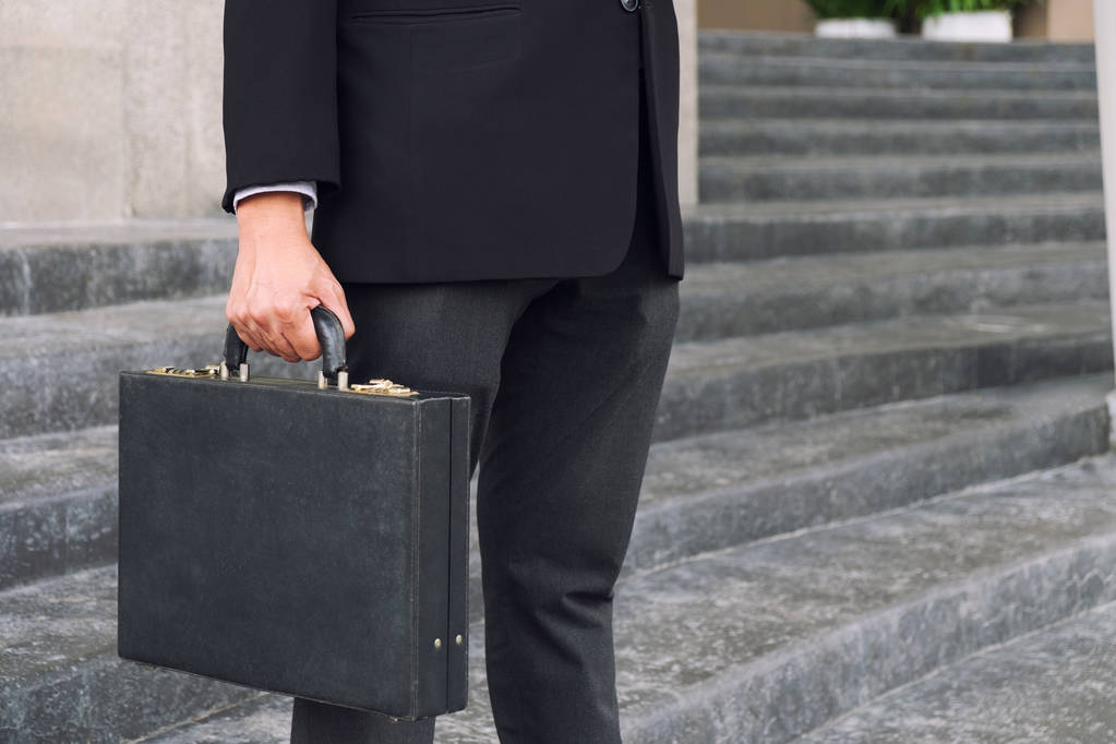 Homme d'affaires debout et tenant une mallette dans la main travaillant esprit
 - Photo, image