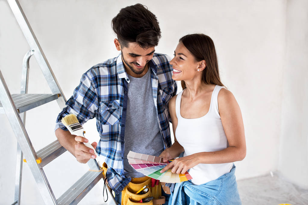 Νεαρό ζευγάρι επιλέγοντας χρώματα για ζωγραφική νέο σπίτι τους - Φωτογραφία, εικόνα