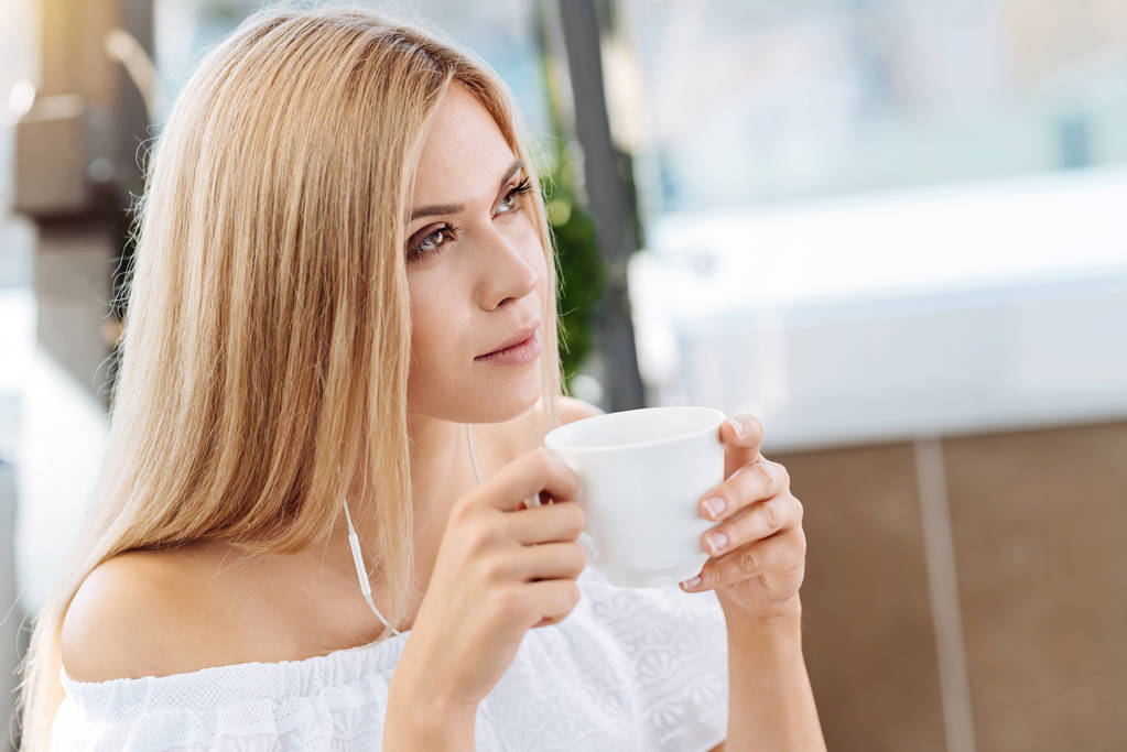 Pensativo joven mujer bebiendo té
 - Foto, Imagen