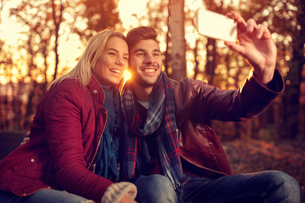 rakkaus puistossa- pari ottaa selfie matkapuhelimella
 - Valokuva, kuva