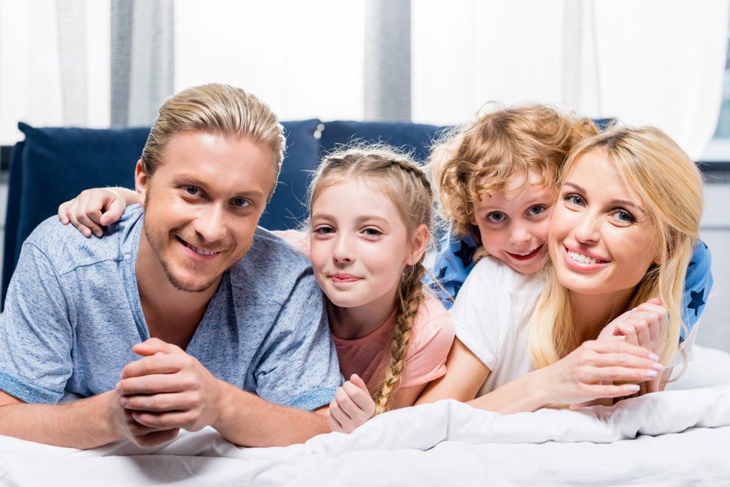 Onnellinen perhe sängyssä
  - Valokuva, kuva