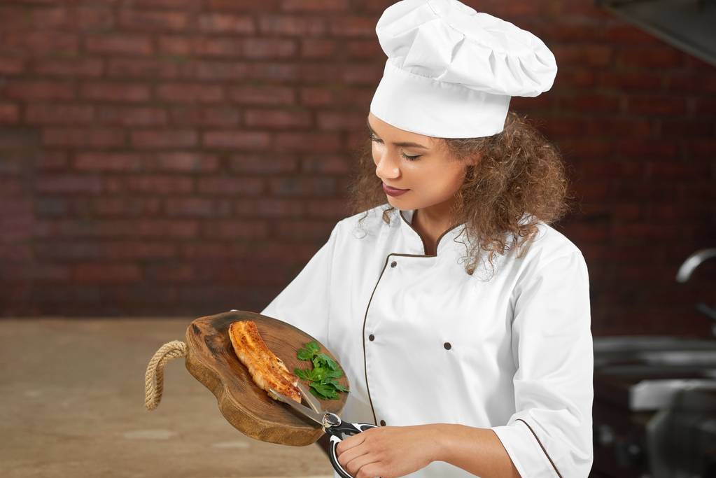 Ammattimainen kokki leikkaa kanan pihvi saksilla
 - Valokuva, kuva