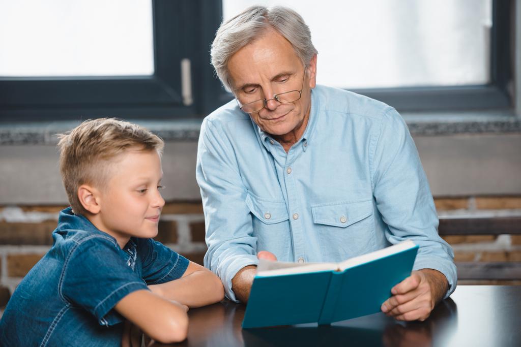 дід і онук читають книгу
  - Фото, зображення