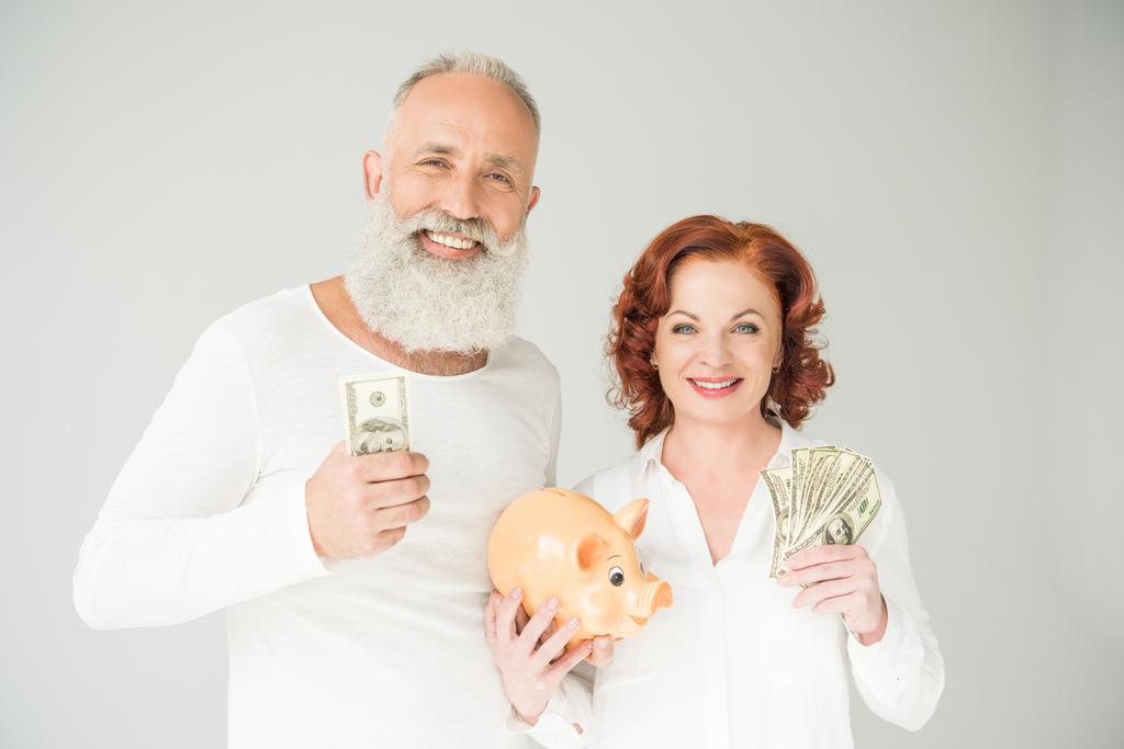 echtpaar met dollars en piggy bank - Foto, afbeelding