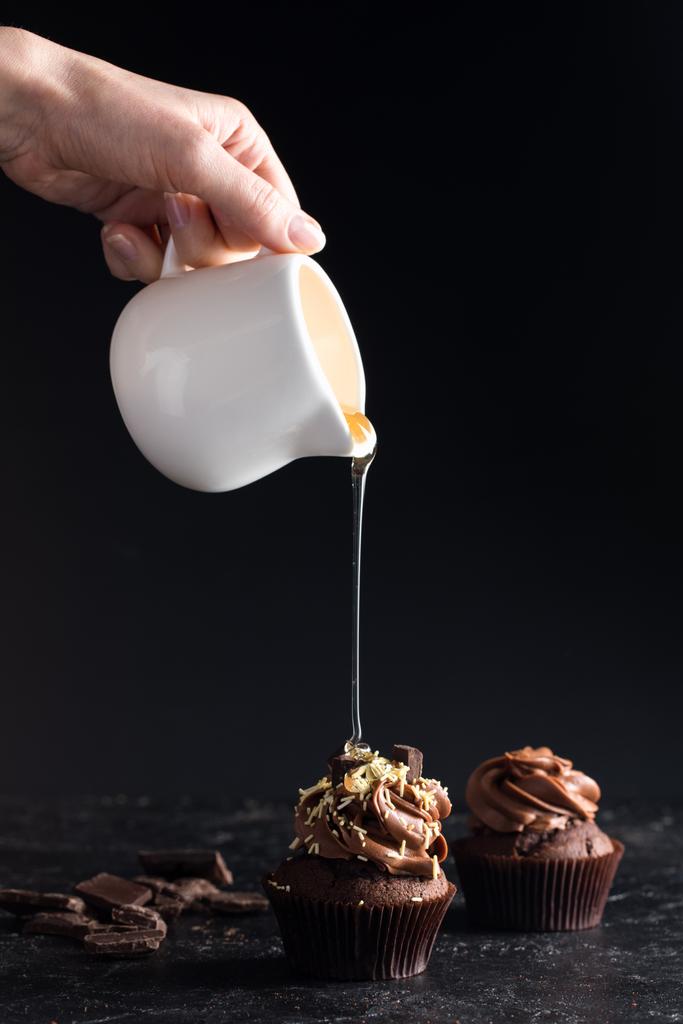 verter el jarabe sobre el cupcake
 - Foto, Imagen