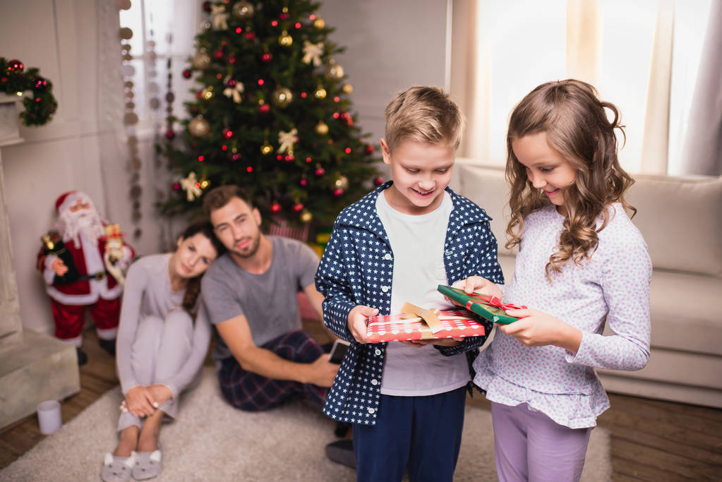 усміхнені діти з різдвяними подарунками
 - Фото, зображення
