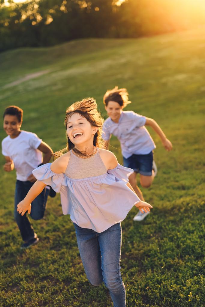 adolescentes multiétnicos corriendo en el parque
 - Foto, imagen