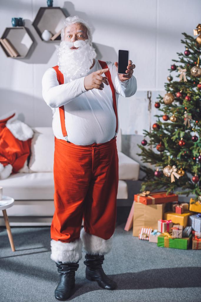 Joulupukki osoittaa älypuhelinta
 - Valokuva, kuva
