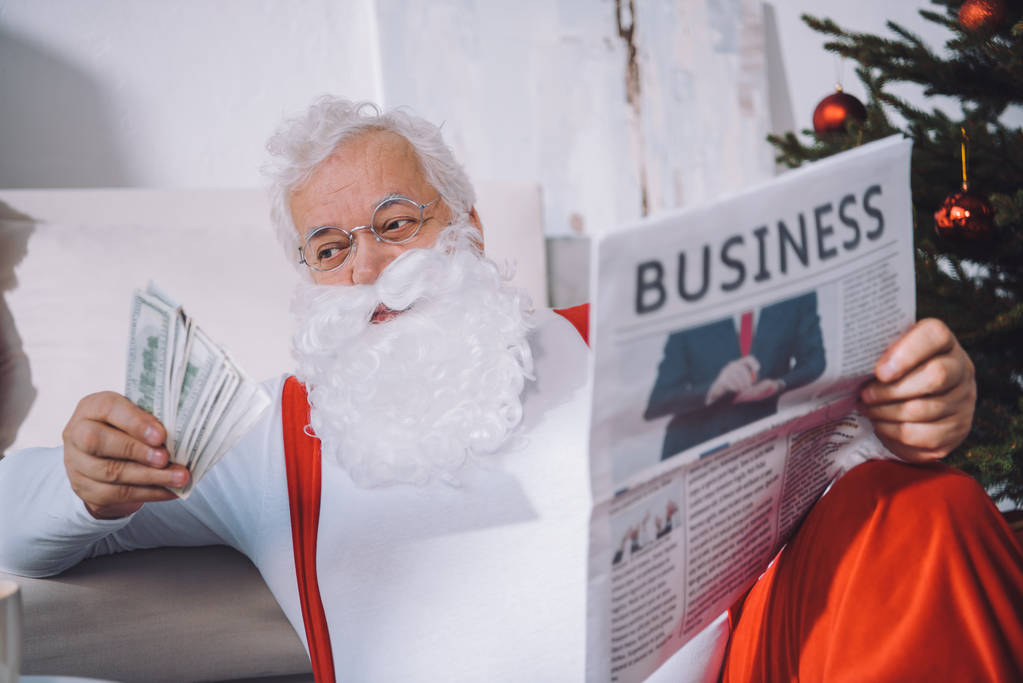 Kerstman met contant geld in de hand - Foto, afbeelding