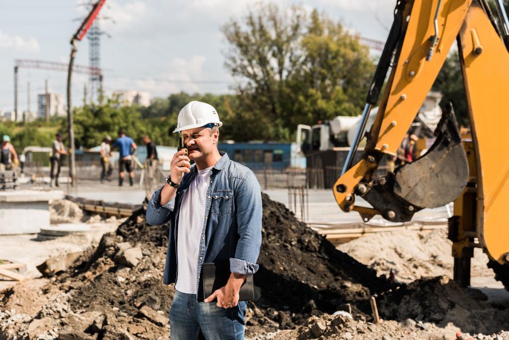 Trabalhador da construção civil com walkie talkie
 - Foto, Imagem