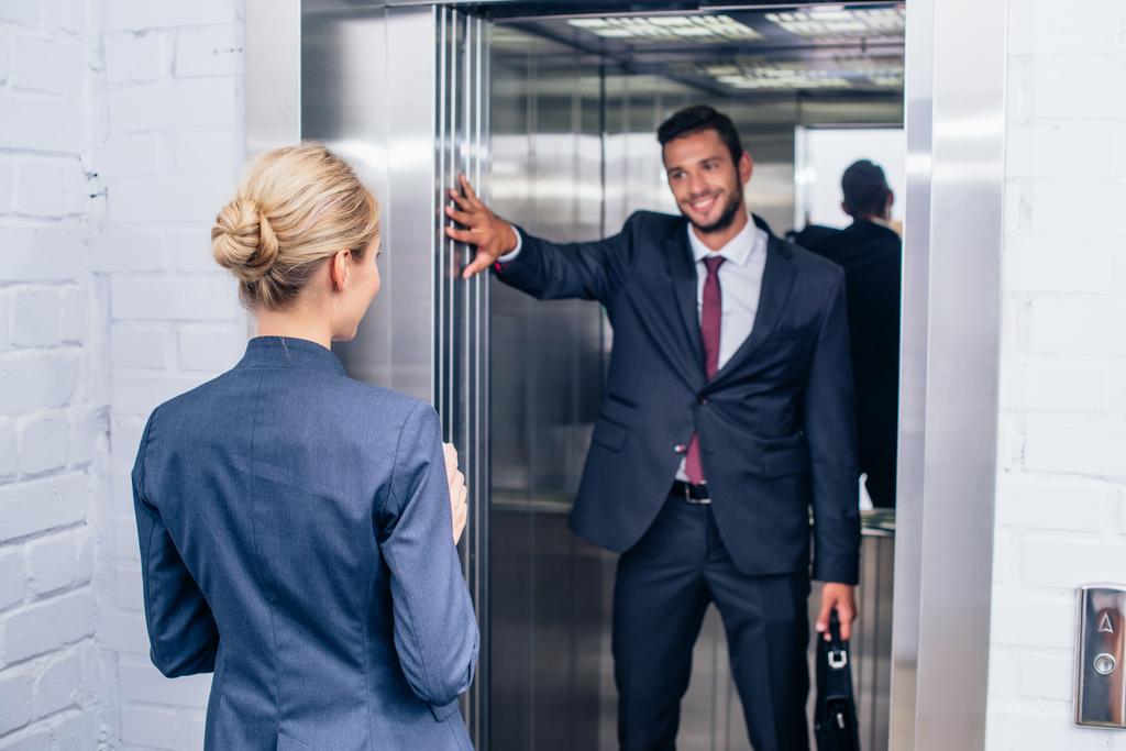 homme d'affaires tenant ascenseur porte pour femme
 - Photo, image