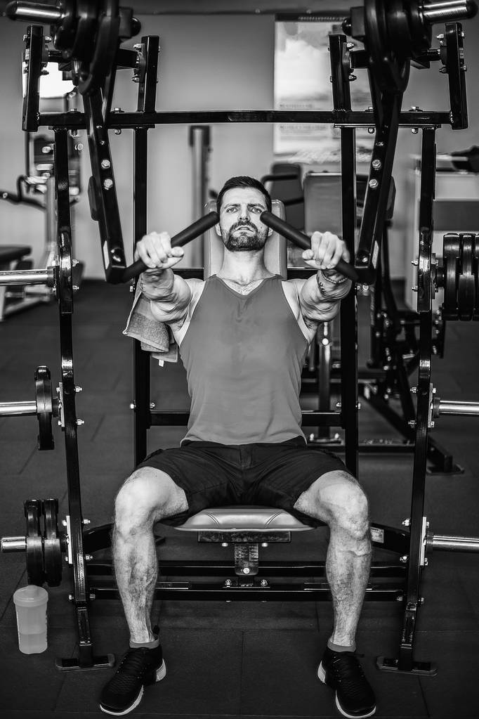El atleta poderoso haciendo ejercicios sobre los músculos pectorales
 - Foto, Imagen