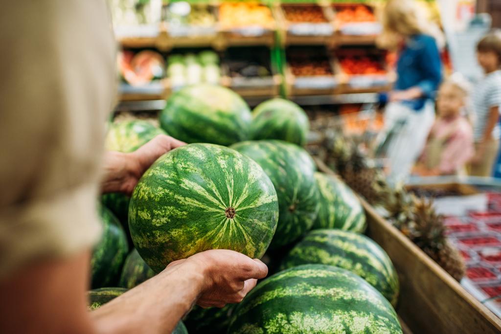 Frau pflückt Wassermelone im Lebensmittelladen - Foto, Bild