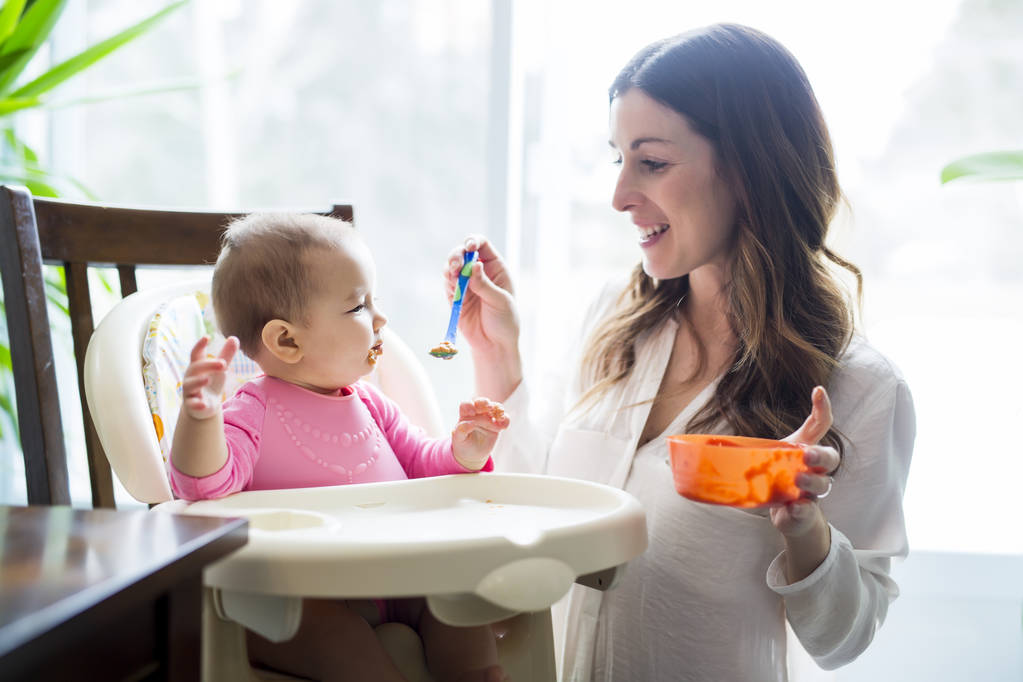 Mutter füttert Baby mit Löffel - Foto, Bild