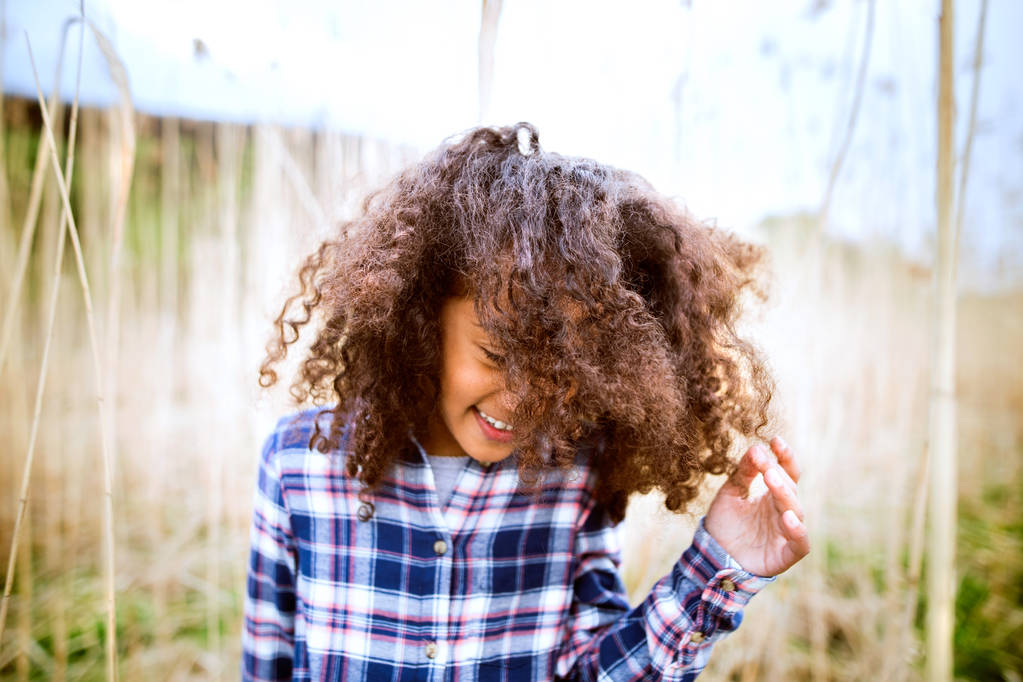 Chica afroamericana en camisa a cuadros al aire libre en el campo
. - Foto, Imagen