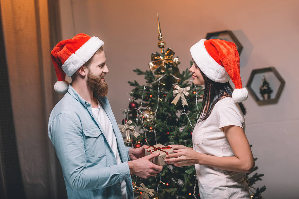 クリスマス プレゼントと若いカップル - 写真・画像
