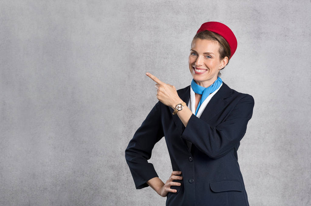 Sorridente hostess aerea mostrando
 - Foto, immagini