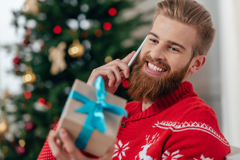 man talking by phone and looking at gift - Photo, Image