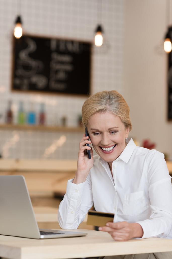 деловая женщина с кредитной картой разговаривает на смартфоне
 - Фото, изображение