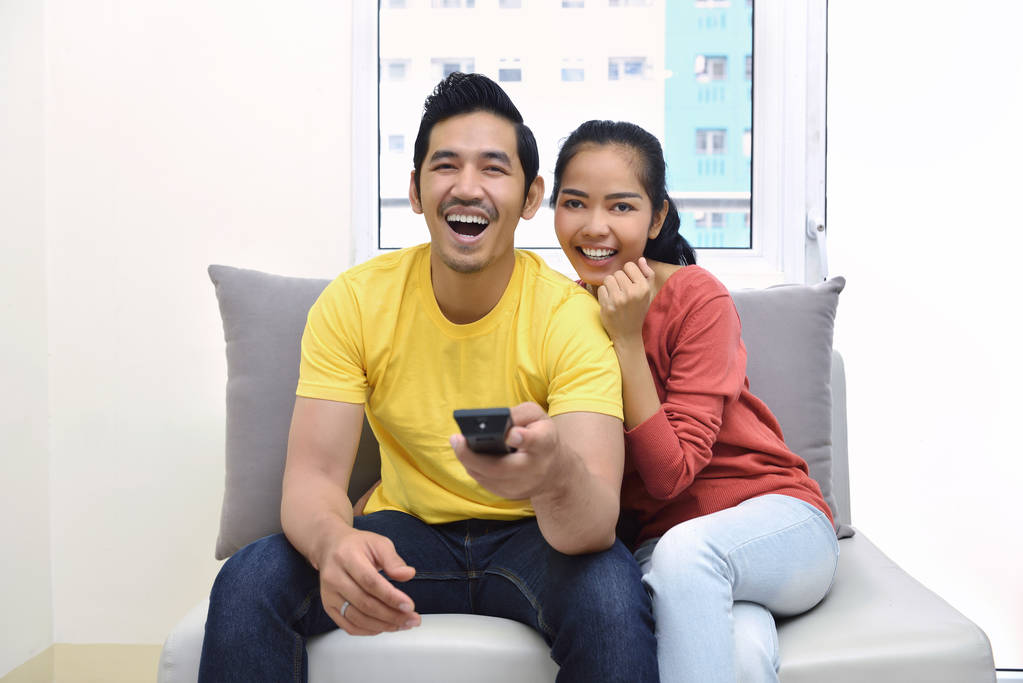 Portret van Aziatische paar genieten van samen televisie kijken - Foto, afbeelding