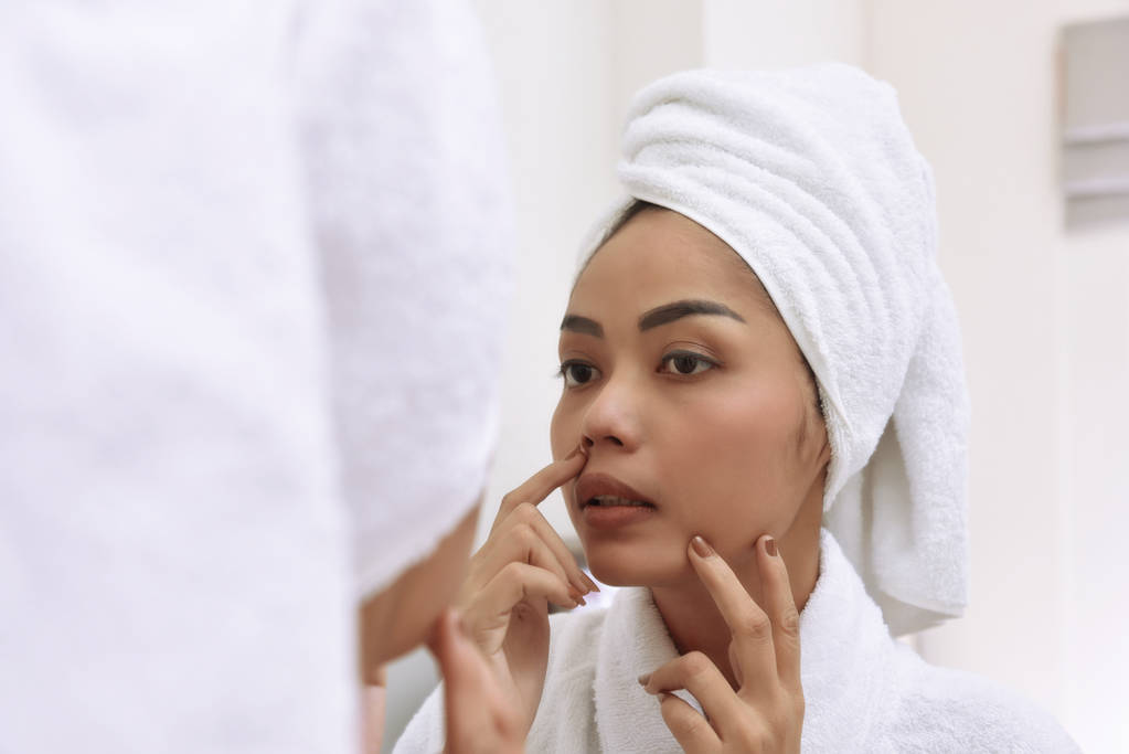 Młoda kobieta azjatyckich z ręczników kąpielowych oczyszcza twarz - Zdjęcie, obraz