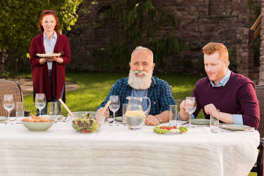 Glückliche Männer sitzen am Tisch - Foto, Bild
