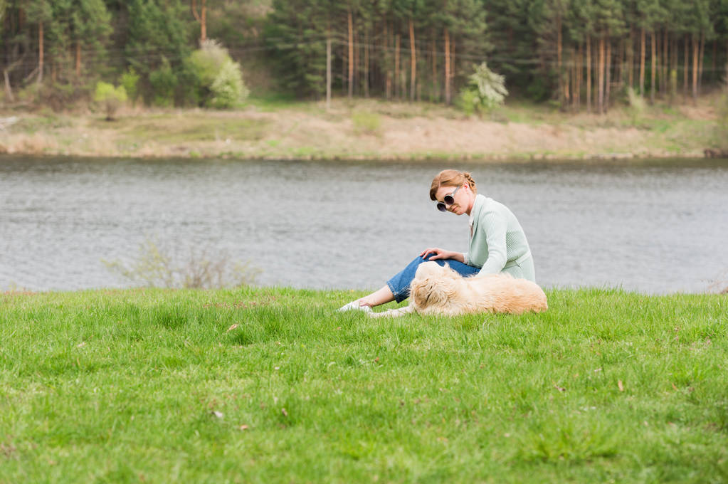 γυναίκα με το σκυλί στο γρασίδι - Φωτογραφία, εικόνα