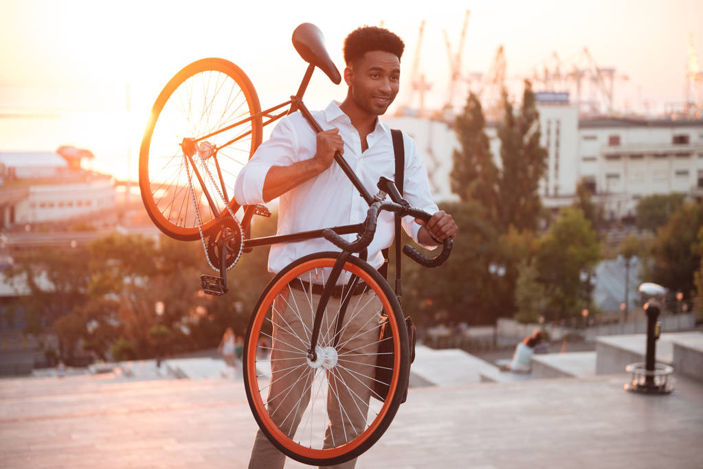 Tiivistetty nuori afrikkalainen mies varhain aamulla polkupyörällä
 - Valokuva, kuva