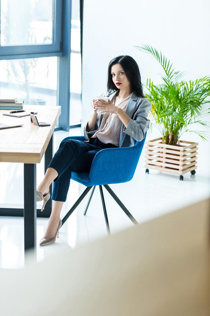 donna d'affari con tazza di caffè sul posto di lavoro
 - Foto, immagini