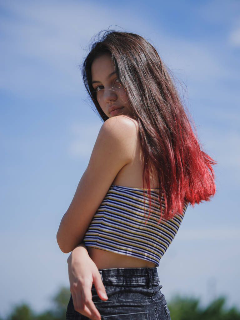 Um retrato de uma adolescente bonita em roupas de verão posando em um fundo natural. Moda, conceito de juventude. Espaço de cópia
. - Foto, Imagem