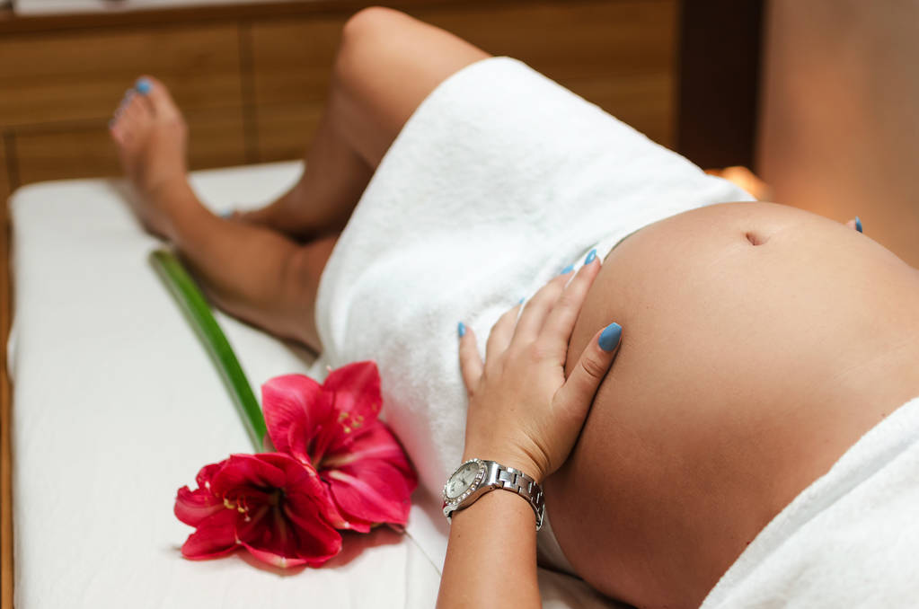 Zwangere vrouw wacht op massage - Foto, afbeelding