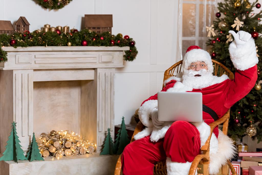 Weihnachtsmann mit Laptop zu Hause - Foto, Bild