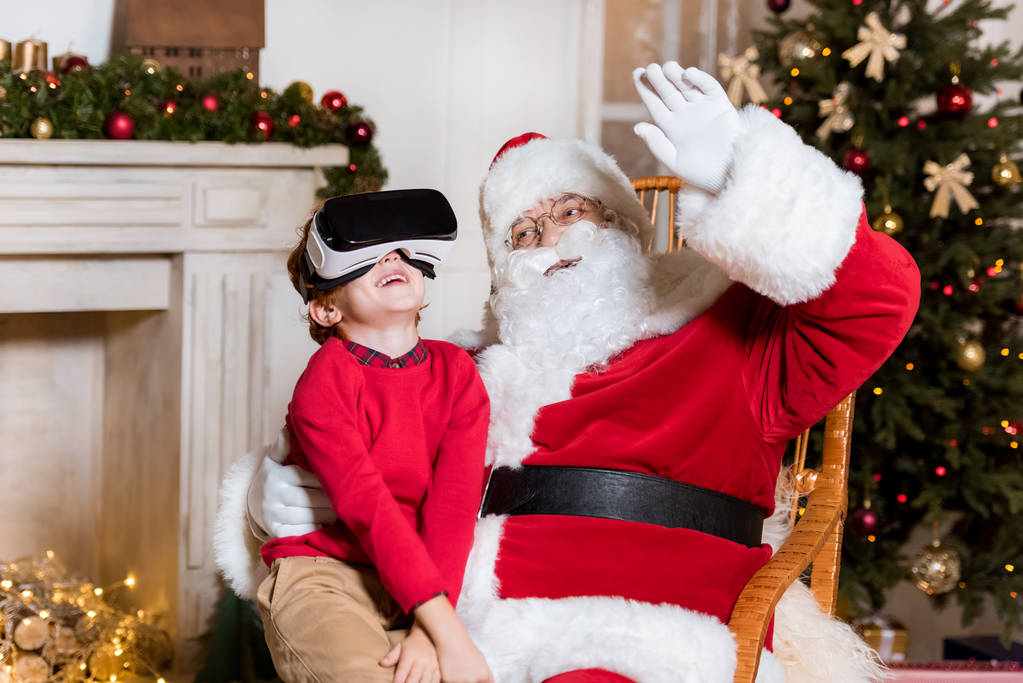 Санта-Клаус и ребенок в наушниках vr
 - Фото, изображение