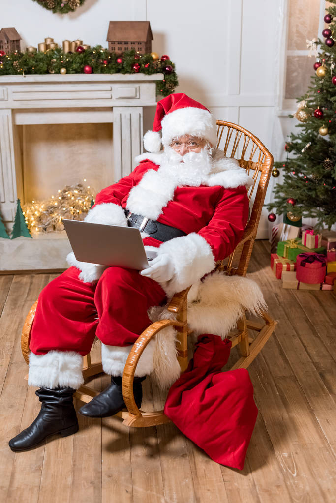 Kerstman met laptop thuis - Foto, afbeelding