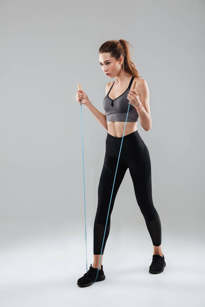 Confident sportswoman doing exercises with a skipping rope - Photo, Image