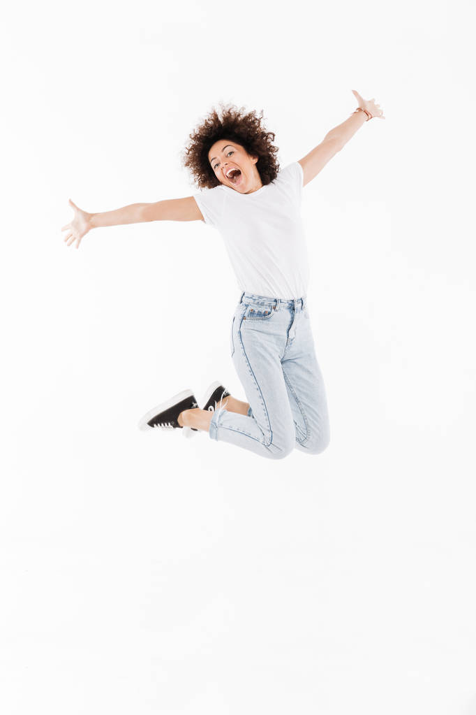 Menina engraçada feliz com cabelo encaracolado saltando
 - Foto, Imagem