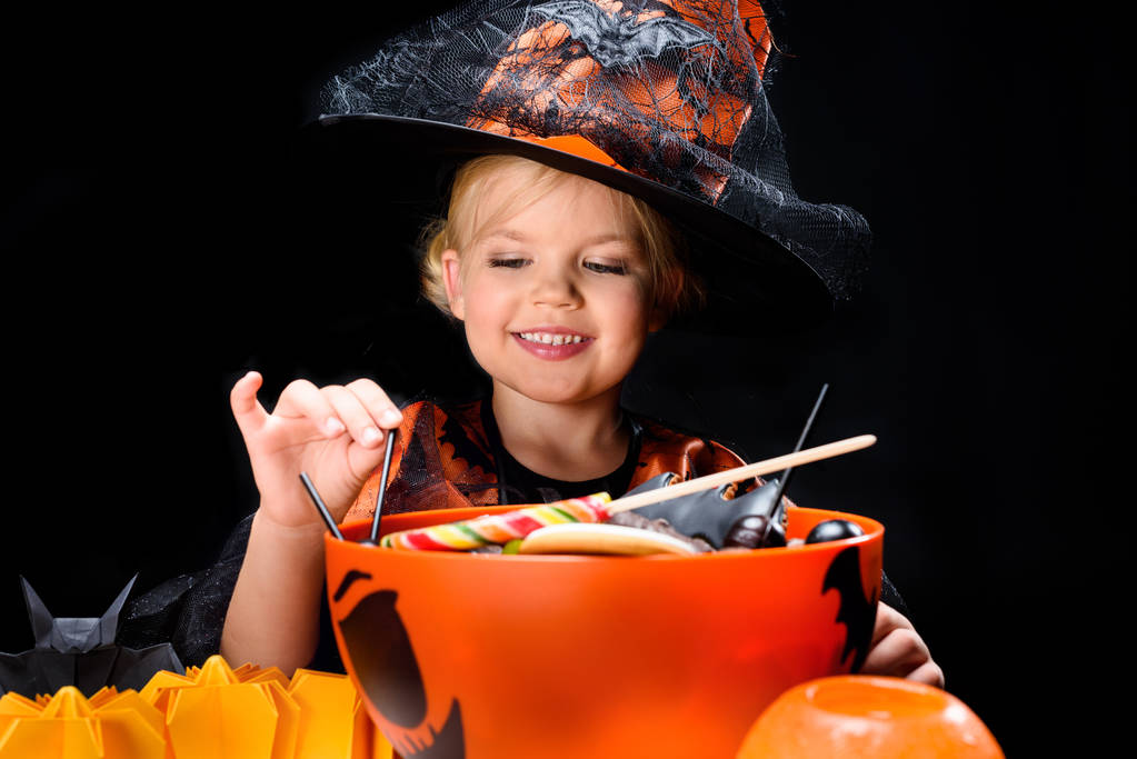 pequeña bruja con dulces de halloween
 - Foto, imagen