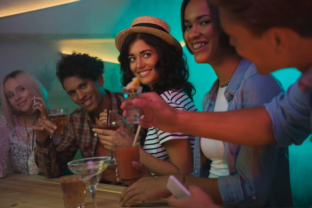 багатоетнічні друзі п'ють коктейлі в барі
 - Фото, зображення