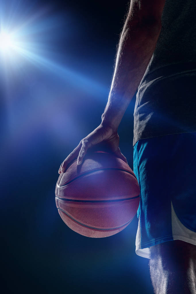 Il ritratto di un giocatore di basket con una palla sullo sfondo scuro studio. concetto di pubblicità
 - Foto, immagini