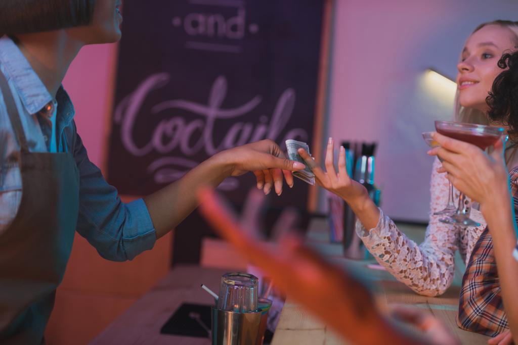 woman paying barman for cocktails - Photo, Image
