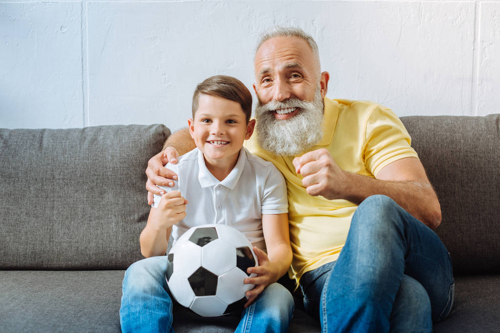 Joyful grandfather and grandson watching football championship game - Photo, Image