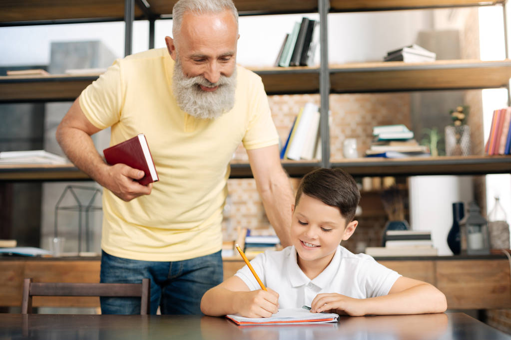 Starostlivý dědeček kontrola výsledky vnuků domácích úkolů - Fotografie, Obrázek