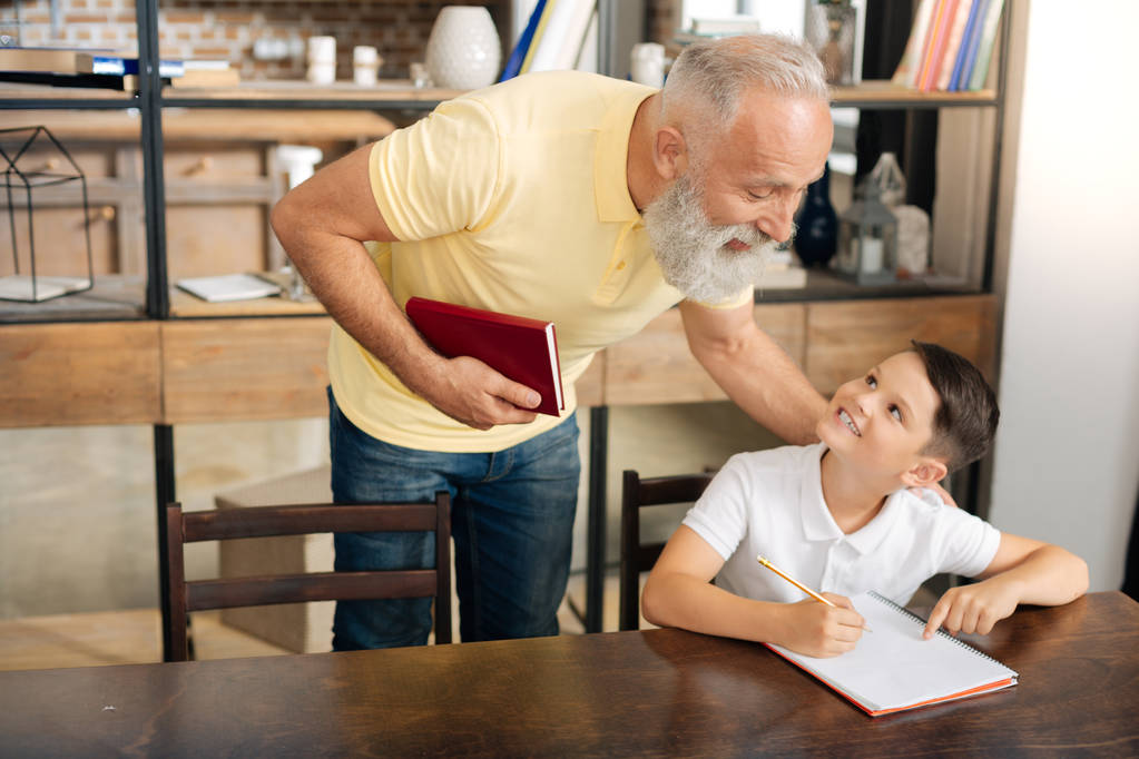 Petit écolier demandant des conseils aux grands-pères sur les devoirs
 - Photo, image