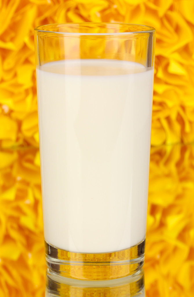 Стакан свежего молока на декоративном желтом фоне с отражением
 - Фото, изображение