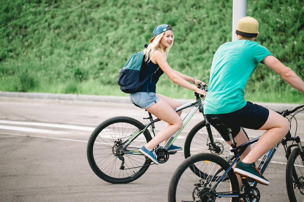 happy couple riding bicycle outdoors at summer from back - Photo, Image