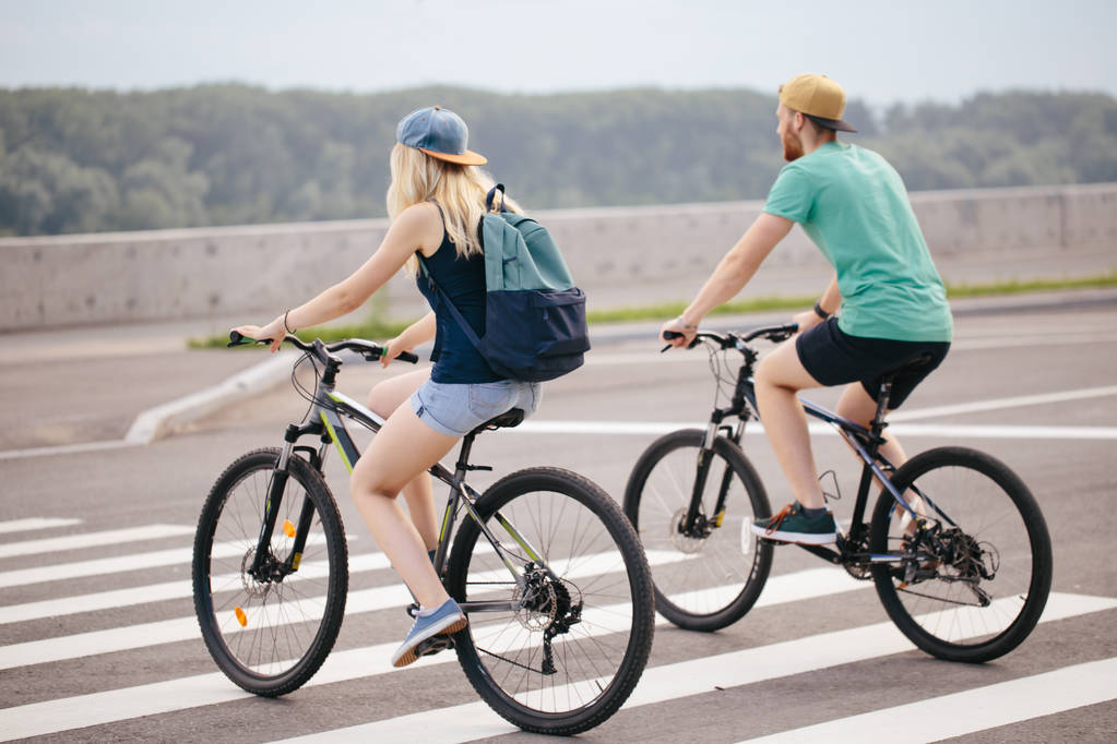 Οπίσθια όψη της ένα ευτυχισμένο ζευγάρι περπάτημα bike εκμετάλλευση - Φωτογραφία, εικόνα
