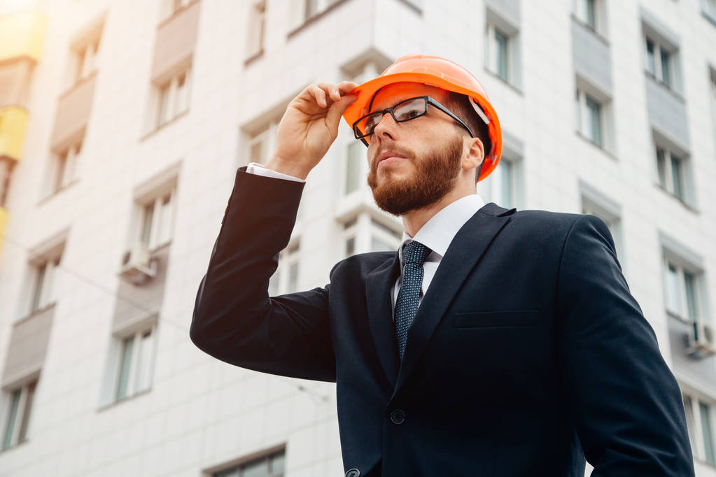 Инженер-строитель в костюме и шлеме на стройке
 - Фото, изображение
