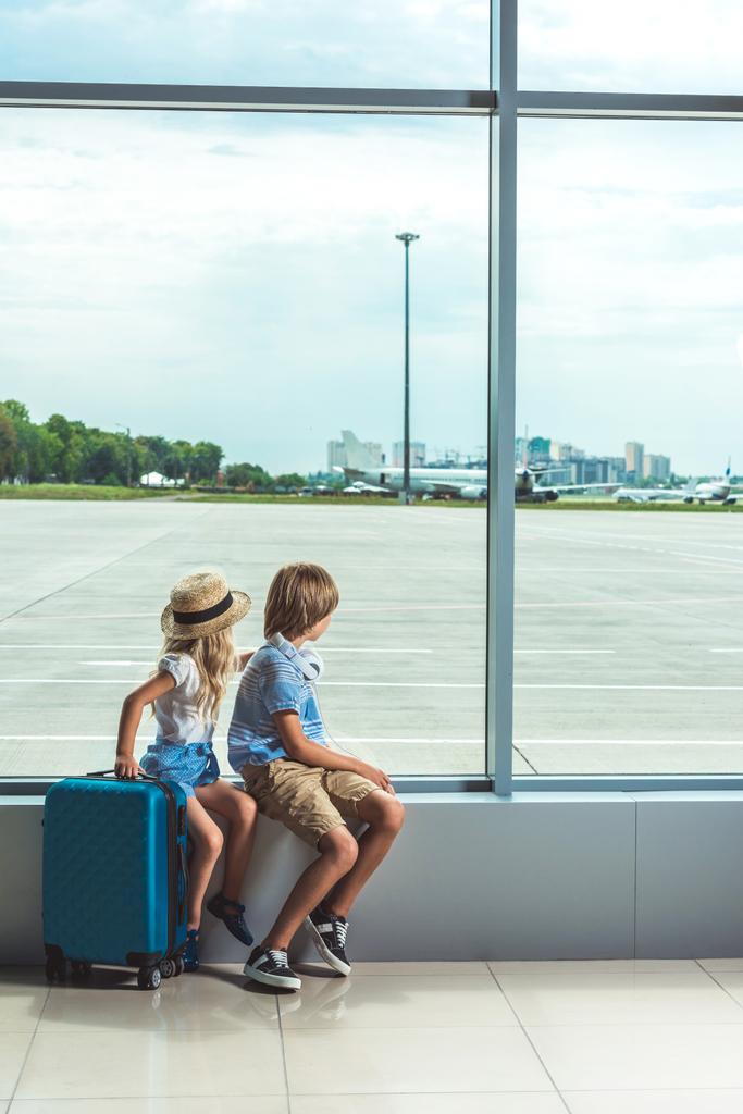 niños mirando por la ventana en el aeropuerto
 - Foto, Imagen