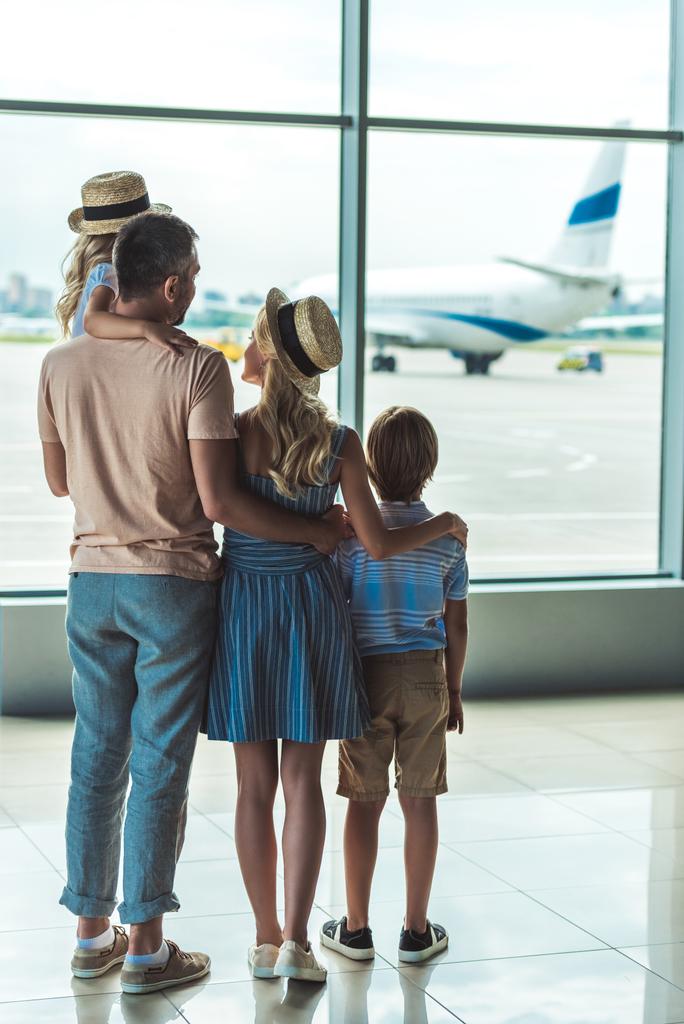 сім'я з видом на вікно в аеропорту
 - Фото, зображення