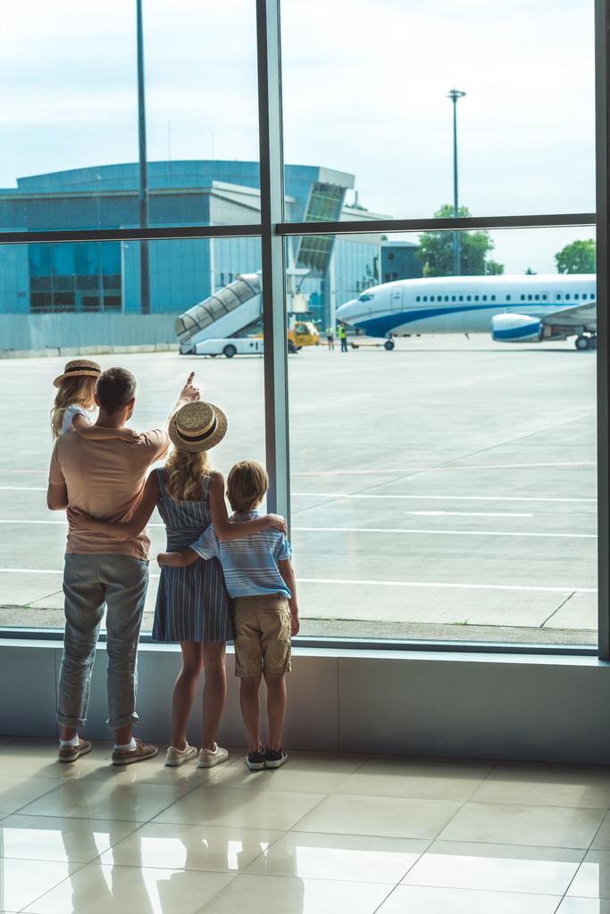 familia mirando por la ventana en aeropuerto
 - Foto, Imagen